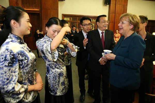 Demonstrating tea customs to Angela Merkel